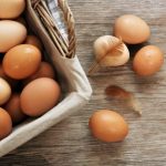 brown-eggs-in-basket-on-wood-table-min
